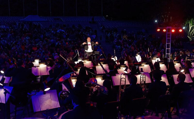 Orquesta sinfónica tocando en un concierto al aire libre