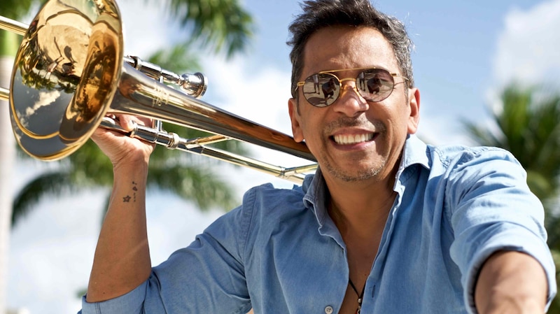 Trombonista sonriendo con gafas de sol