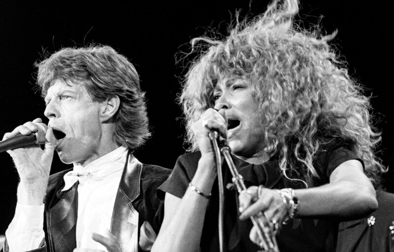 Mick Jagger y Tina Turner cantando juntos en un concierto.