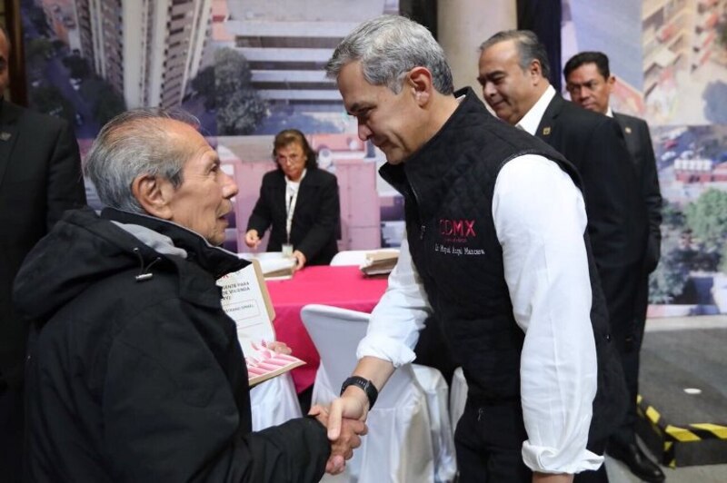 El presidente López Obrador saluda a un adulto mayor durante un evento en la Ciudad de México.