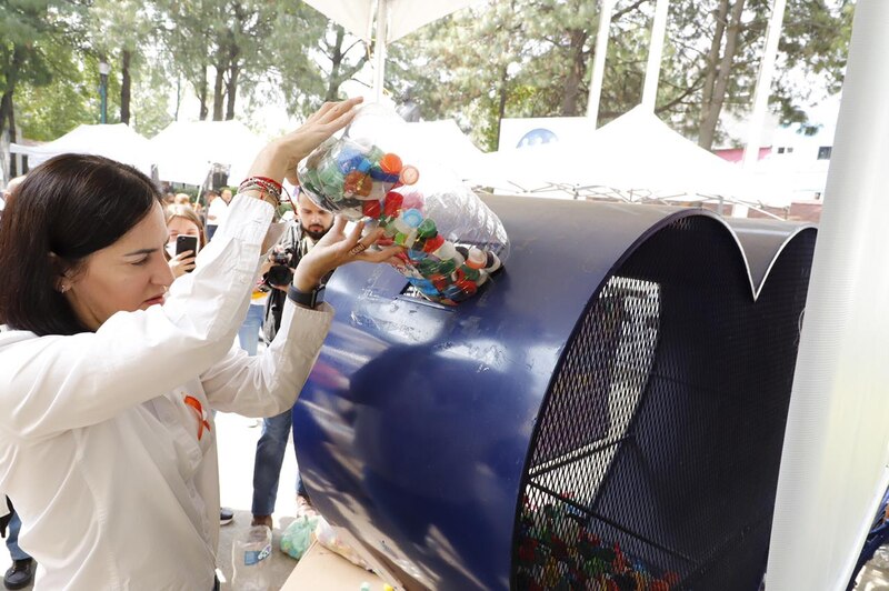 Mujer reciclando botellas de plástico