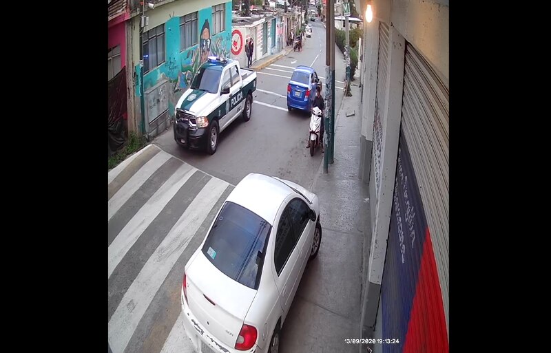 Policía detiene a un motociclista en una calle de la ciudad.