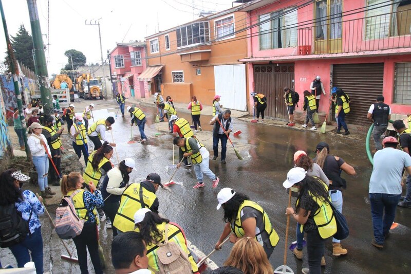 Voluntarios limpian una calle inundada