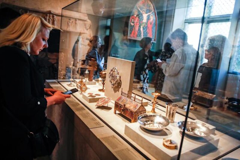 Mujer mirando una vitrina de objetos religiosos en un museo