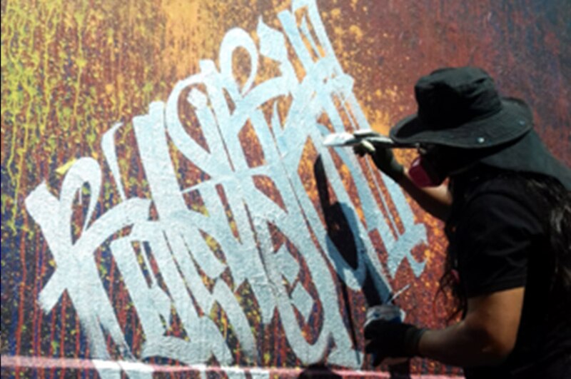Artista urbano pinta un mural en la calle