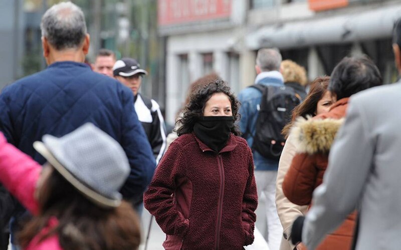 Mujer con mascarilla caminando por la calle