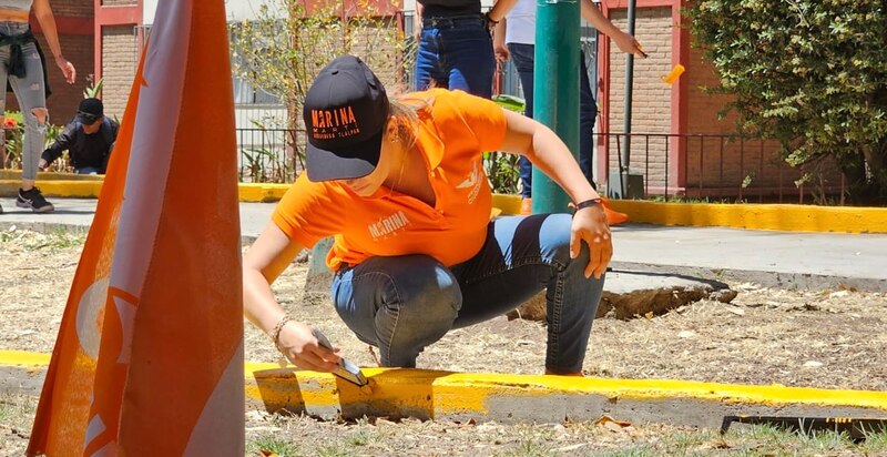 Voluntarios pintando un mural en una calle