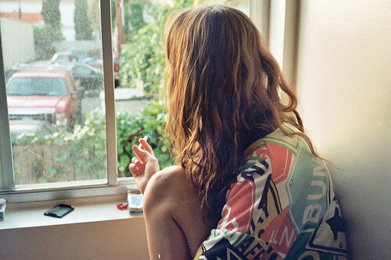 Mujer joven mirando por la ventana