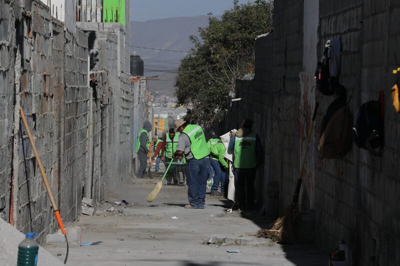 Trabajadores municipales retiran basura y escombro de un callejón en Saltillo como parte del programa “Aquí Andamos”