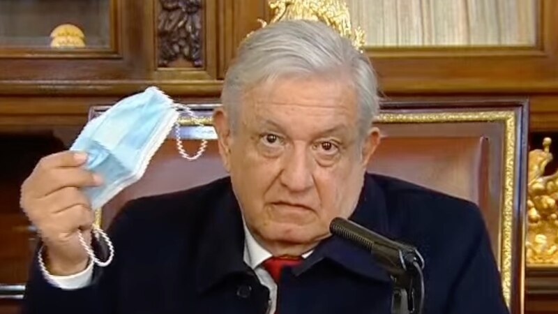 El presidente López Obrador muestra una mascarilla durante una conferencia de prensa