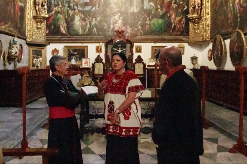 Sacerdotisa da un recorrido por la iglesia a un hombre y a una mujer