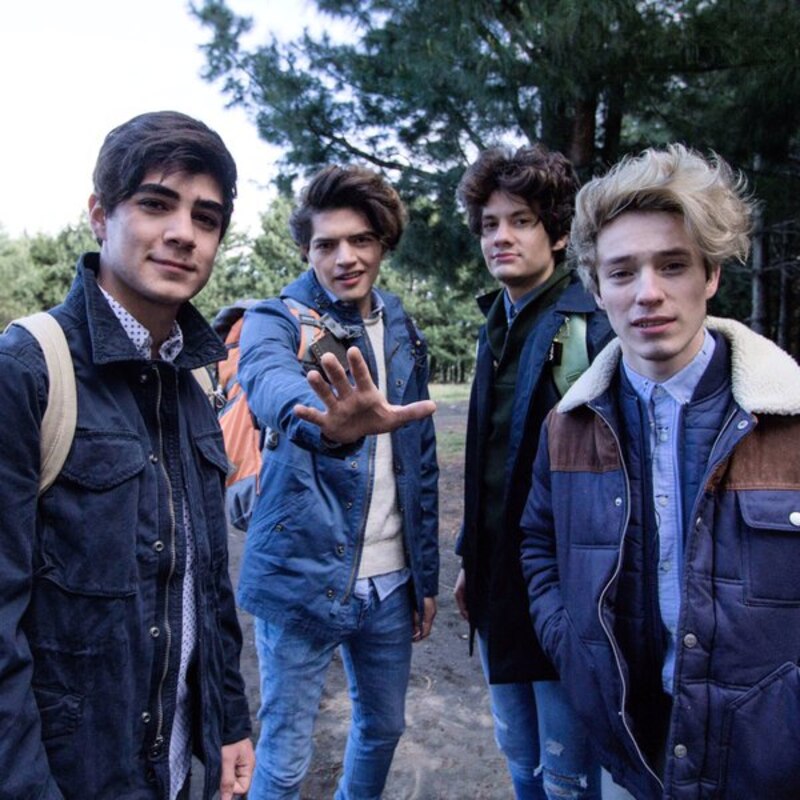 Cuatro chicos adolescentes sonríen a la cámara.