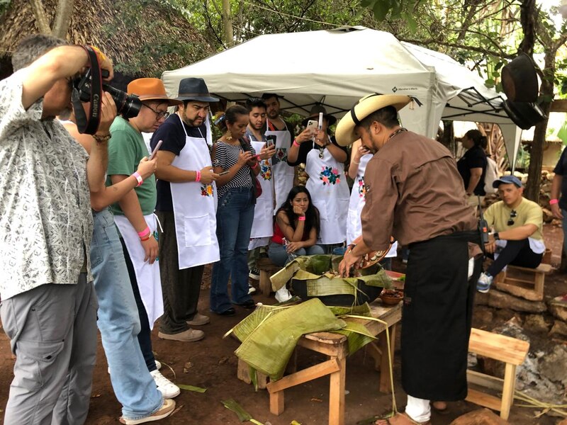 Un grupo de personas observa cómo se prepara un tamal.