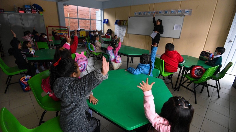 Niños en el aula levantando la mano para participar