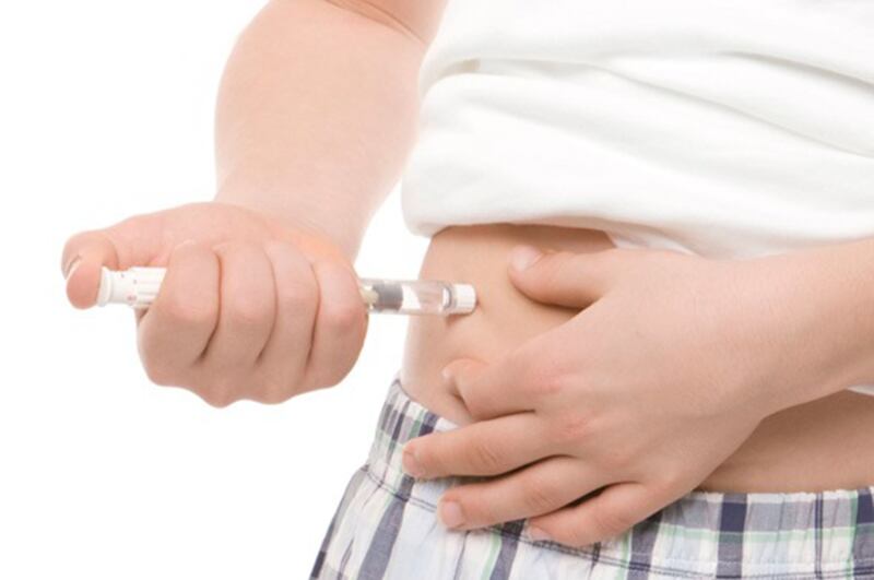Niño con diabetes se inyecta insulina