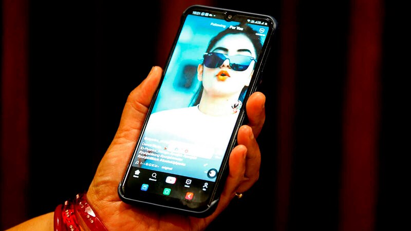 Una mujer joven está usando su teléfono móvil.