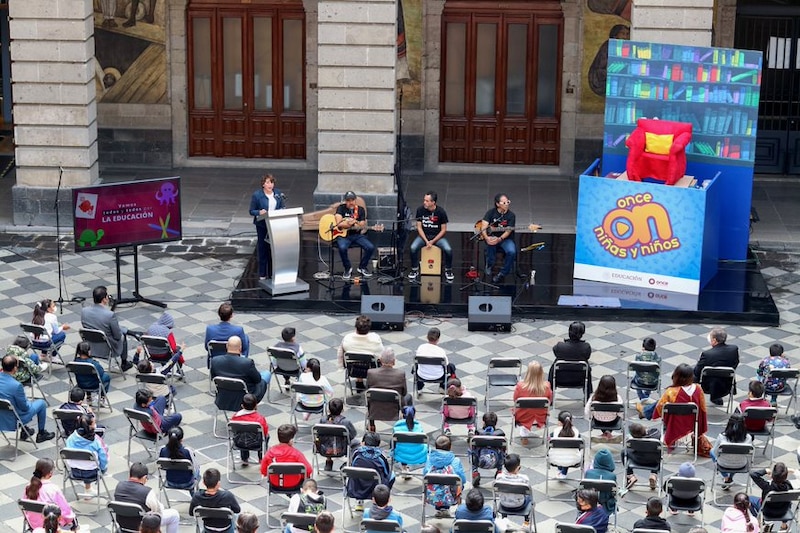 Un grupo de personas viendo un concierto al aire libre.