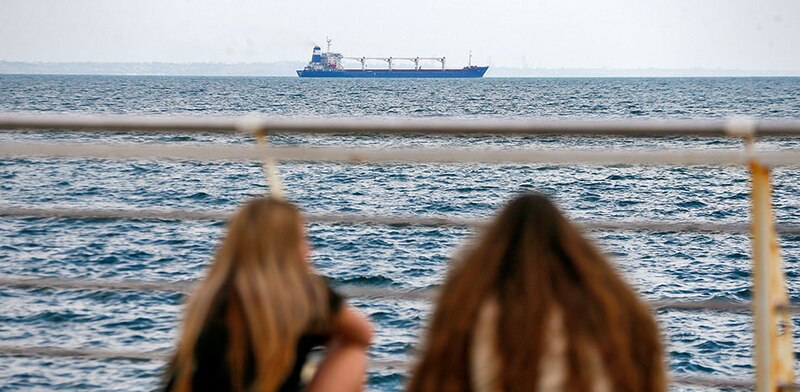 Dos mujeres mirando un barco en el mar